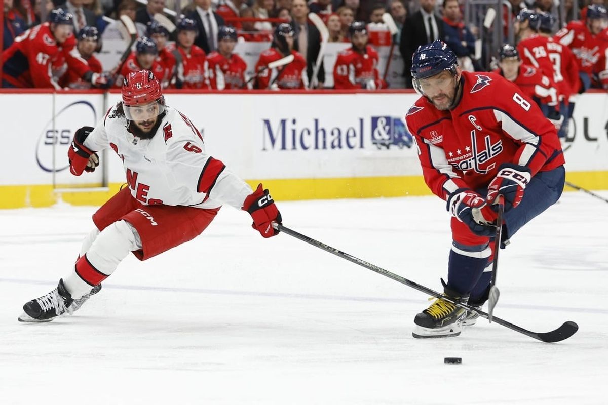 Jan 5, 2024; Washington, District of Columbia, USA; Washington Capitals left wing Alex Ovechkin (8) and Carolina Hurricanes defenseman Jalen Chatfield (5) battle for the puck d3p/ at Capital One Arena.