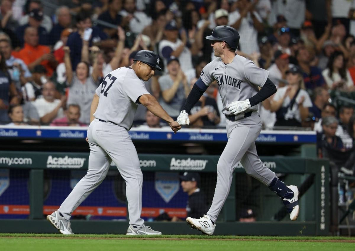 Sep 4, 2025; Houston, Texas, USA; New York Yankees third base/outfield coach Luis Rojas (67) celebrates third baseman Ryan McMahon (19) home run against the Houston Astros  in the fifth inning at Daikin Park. Mandatory Credit: Thomas Shea-Imagn Images