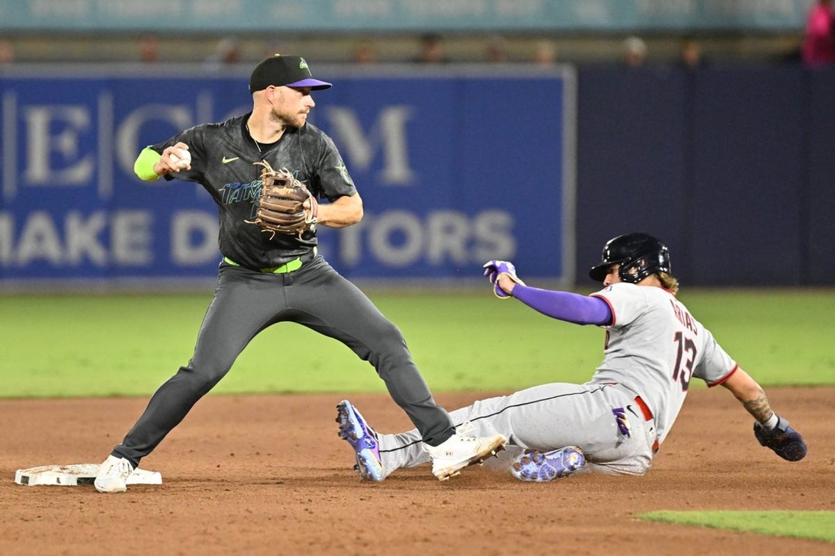 Sep 5, 2025; St. Petersburg, Florida, USA; Tampa Bay Rays second baseman Brandon Lowe (8) throws to first base as Cleveland Guardians short stop Gabriel Arias (13) slides  in the third inning at George M. Steinbrenner Field. Mandatory Credit: Jonathan Dyer-Imagn Images