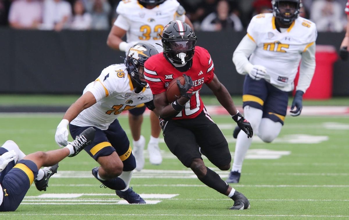 Sep 6, 2025; Lubbock, Texas, USA;  Texas Tech Red Raiders running back J’Koby Williams (20) rushes against Kent State Golden Flashes defensive back Sayed Abuhamdeh (15) in the first half at Jones AT&T Stadium. Mandatory Credit: Michael C. Johnson-Imagn Images