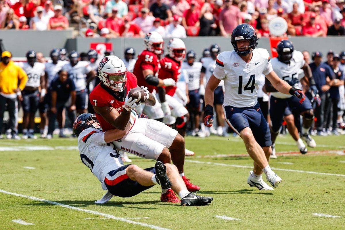 Sep 6, 2025; Raleigh, North Carolina, USA; Virginia Cavaliers safety Ethan Minter (30) tackles North Carolina State Wolfpack tight end Justin Joly (7) during the first half of the game at Carter-Finley Stadium. Mandatory Credit: Jaylynn Nash-Imagn Images