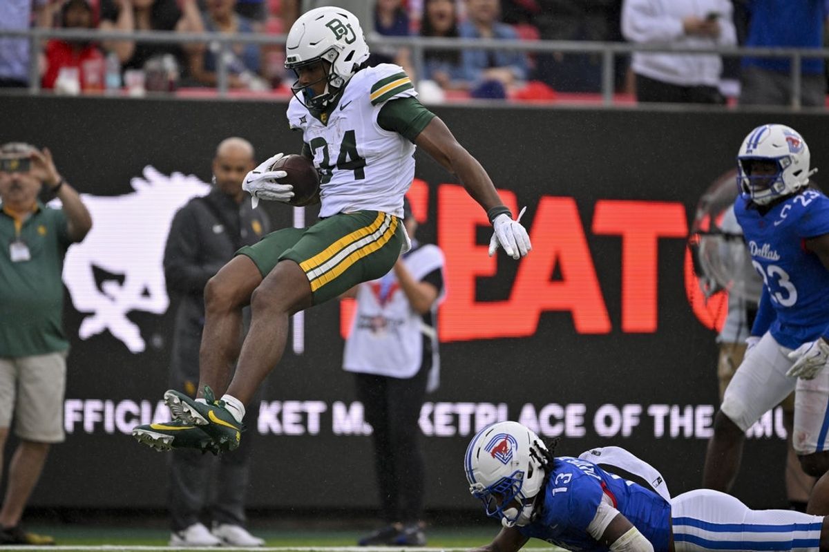 Sep 6, 2025; Dallas, Texas, USA; Baylor Bears wide receiver Josh Cameron (34) leaps over SMU Mustangs cornerback Jaelyn Davis-Robinson (13) and scores a touchdown during the second quarter at Gerald J. Ford Stadium. Mandatory Credit: Jerome Miron-Imagn Images