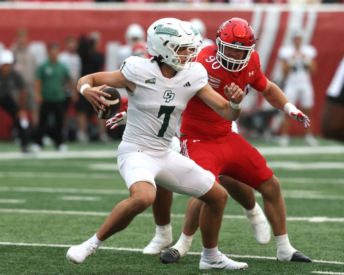 Sep 6, 2025; Salt Lake City, Utah, USA; Cal Poly Mustangs quarterback Ty Dieffenbach (7) avoids a tackle by Utah Utes defensive end John Henry Daley (90) during the first quarter at Rice-Eccles Stadium. Mandatory Credit: Rob Gray-Imagn Images