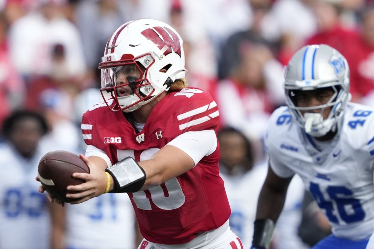 Sep 6, 2025; Madison, Wisconsin, USA; Wisconsin Badgers quarterback Danny O'Neil (18) hands off the ball against the Middle Tennessee Blue Raiders during the first half at Camp Randall Stadium. Mandatory Credit: Kayla Wolf-Imagn Images