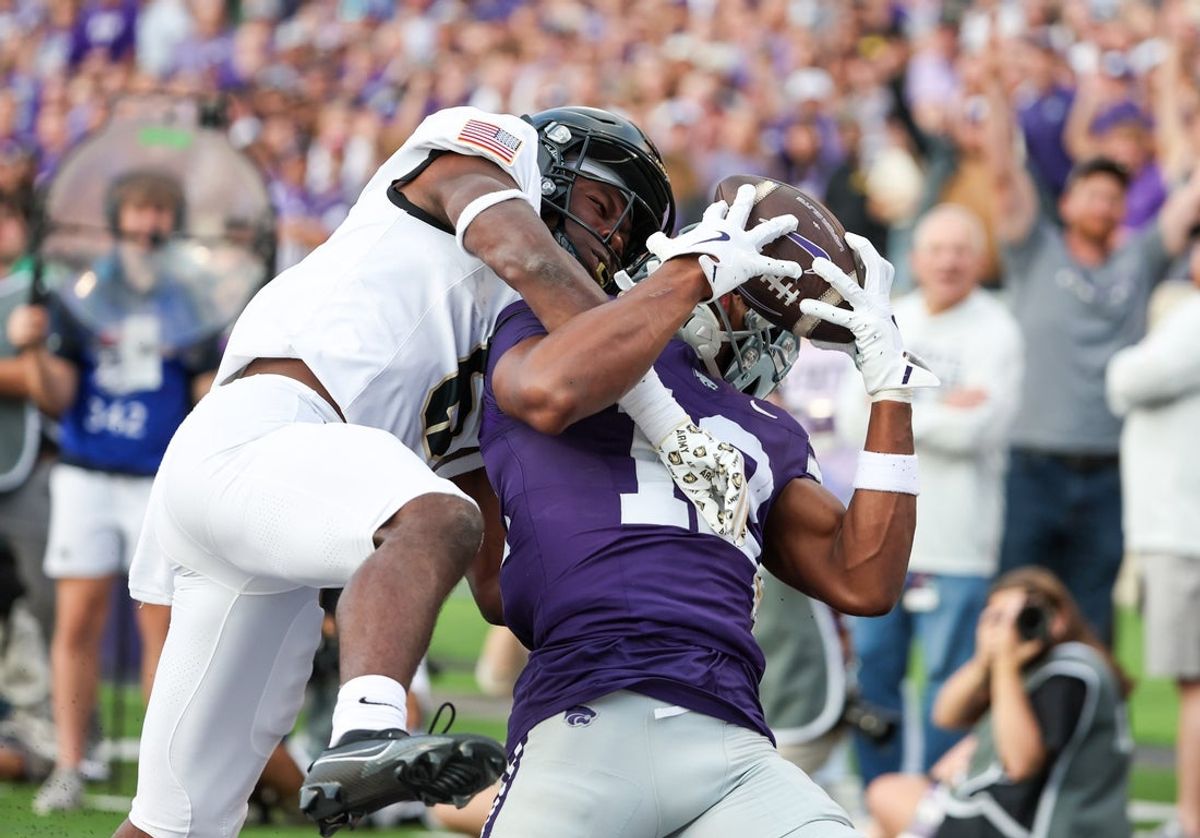Sep 6, 2025; Manhattan, Kansas, USA; Kansas State Wildcats wide receiver Jaron Tibbs (12) makes a touchdown catch against Army Black Knights cornerback Jabril Williams (6) during the second quarter at Bill Snyder Family Football Stadium. Mandatory Credit: Scott Sewell-Imagn Images