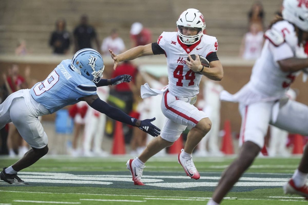Sep 6, 2025; Houston, Texas, USA; Houston Cougars running back Dean Connors (44) runs with the ball as Rice Owls safety Peyton Stevenson (9) attempts to make a tackle during the first quarter at Rice Stadium. Mandatory Credit: Troy Taormina-Imagn Images