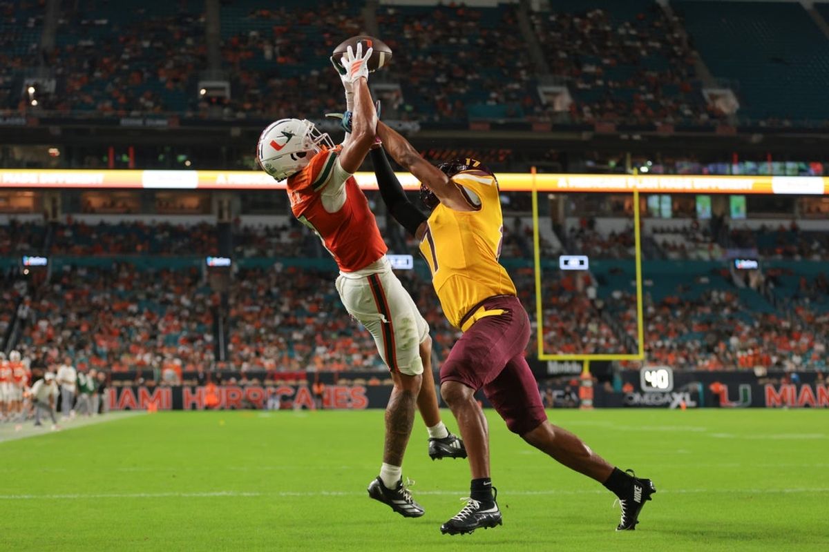 Sep 6, 2025; Miami Gardens, Florida, USA; Miami Hurricanes wide receiver CJ Daniels (7) catches the football for a touchdown against Bethune-Cookman Wildcats cornerback Gabe White (17) during the second quarter at Hard Rock Stadium. Mandatory Credit: Sam Navarro-Imagn Images