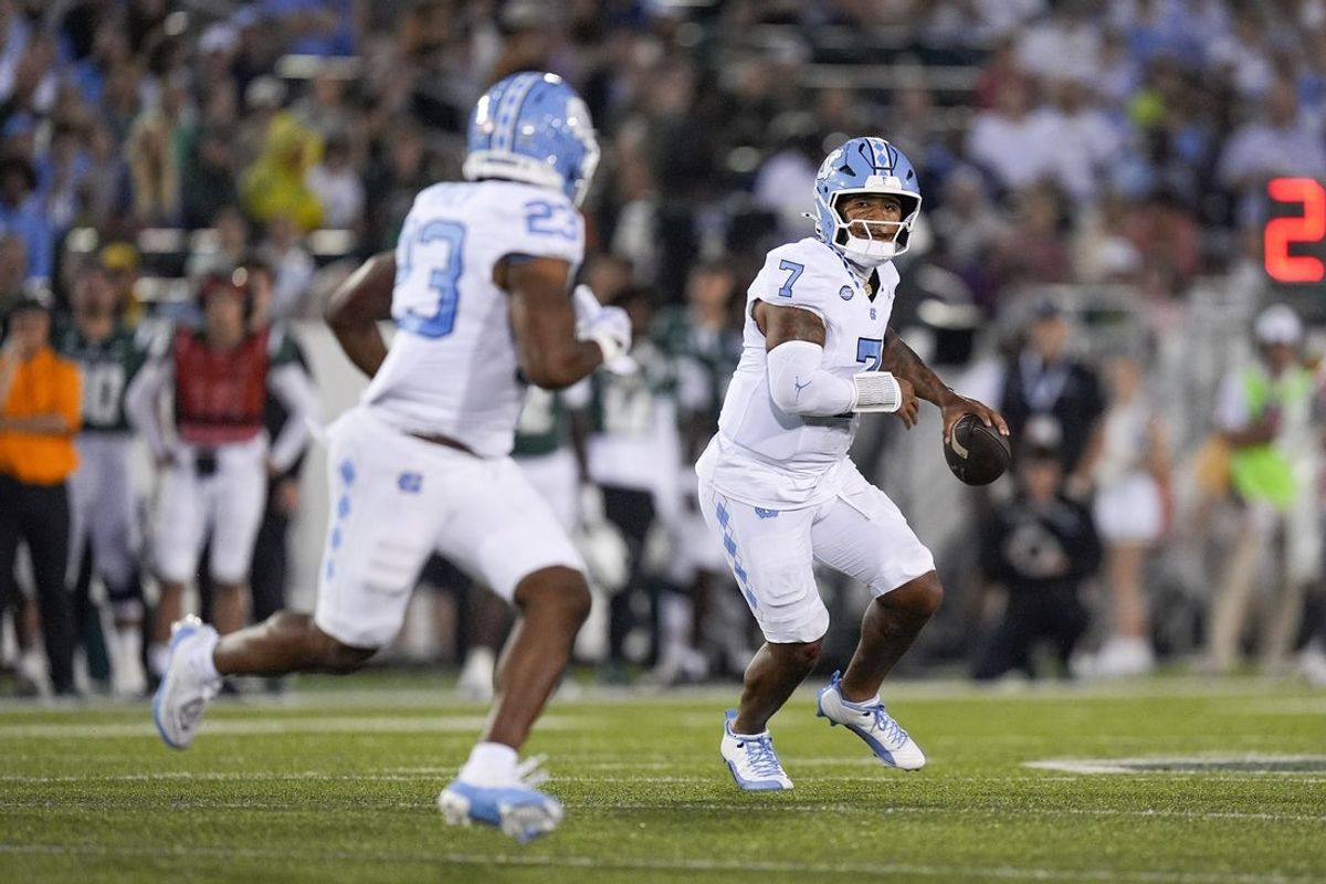 Sep 6, 2025; Charlotte, North Carolina, USA; North Carolina Tar Heels quarterback Gio Lopez (7) looks to throw to running back Charleston French (23) during the first quarter against the Charlotte 49ers at Jerry Richardson Stadium. Mandatory Credit: Jim Dedmon-Imagn Images
