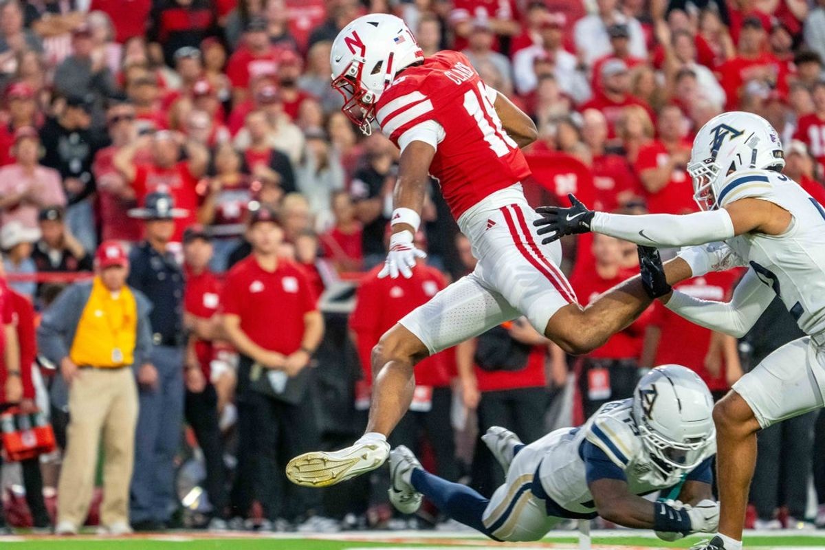 Sep 6, 2025; Lincoln, Nebraska, USA; Nebraska Cornhuskers wide receiver Quinn Clark (18) hurdles Akron Zips defensive back Terence Thomas (15) during the second quarter at Memorial Stadium. Mandatory Credit: Dylan Widger-Imagn Images