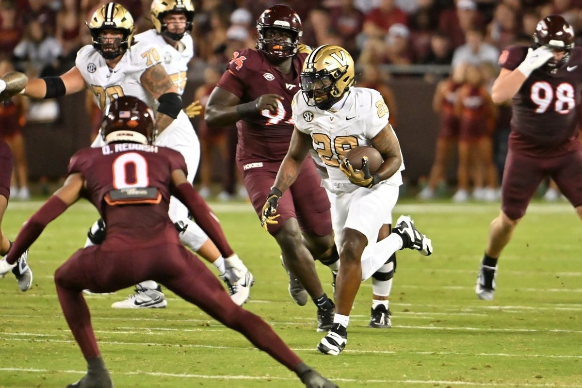 Sep 6, 2025; Blacksburg, Virginia, USA;  Vanderbilt Commodores running back Sedrick Alexander (28) runs the ball as Virginia Tech Hokies safety Quentin Reddish (0) defends during the second quarter at Lane Stadium. Mandatory Credit: Brian Bishop-Imagn Images