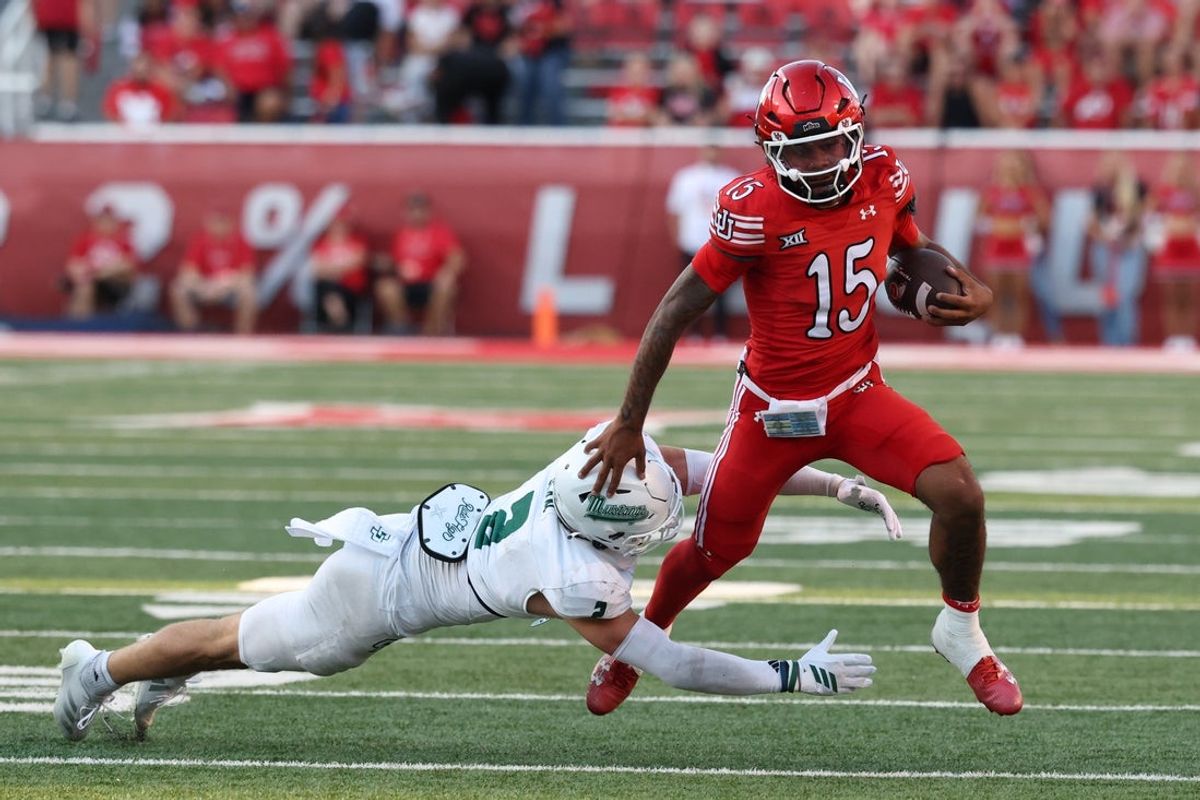 Sep 6, 2025; Salt Lake City, Utah, USA; Utah Utes quarterback Byrd Ficklin (15) is tackled by Cal Poly Mustangs linebacker Troy Bean (2) during the second half at Rice-Eccles Stadium. Mandatory Credit: Rob Gray-Imagn Images