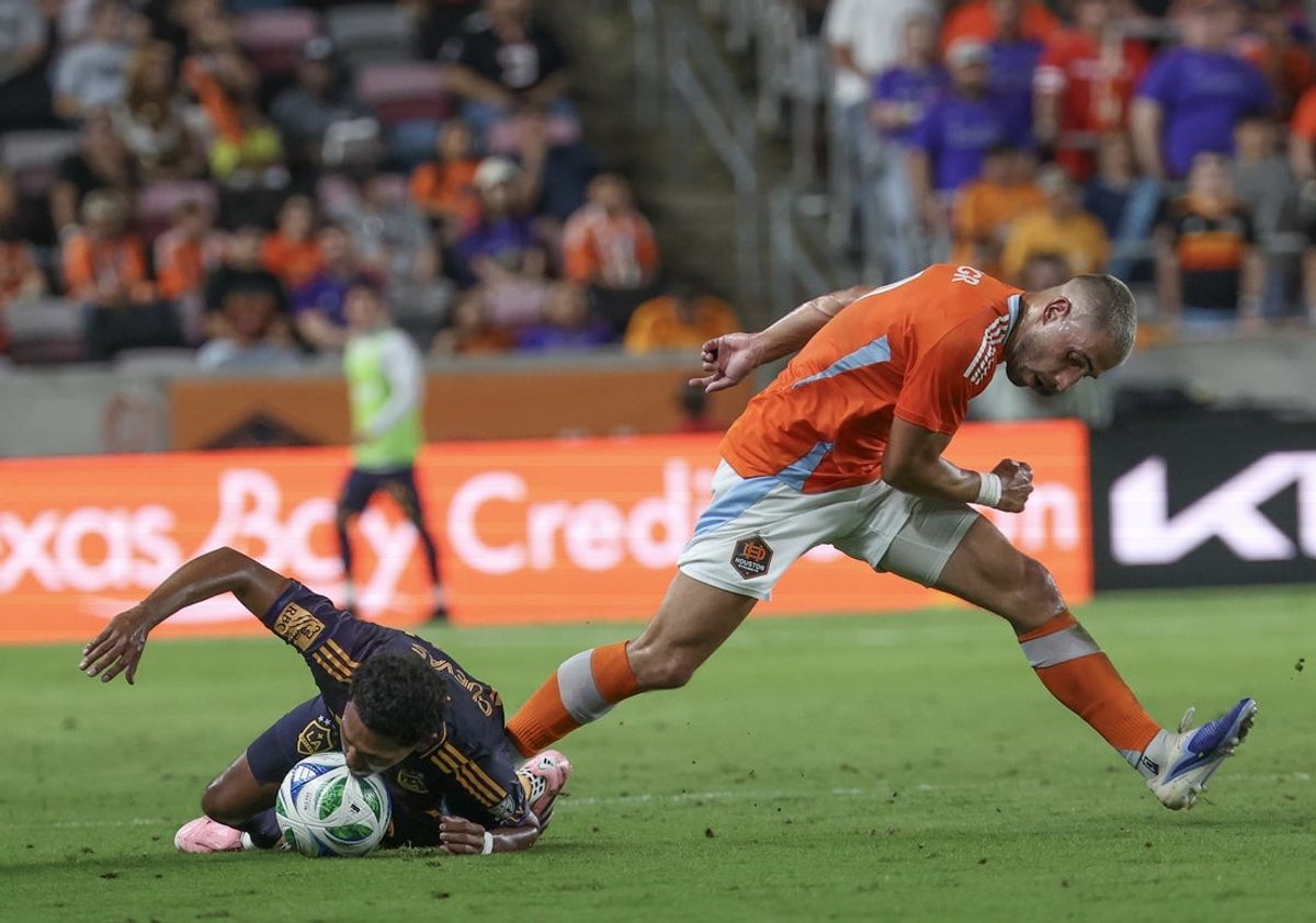 Sep 6, 2025; Houston, Texas, USA; Los Angeles Galaxy defender Mauricio Cuevas (19) stops the ball with his head as Houston Dynamo FC midfielder Ondrej Lingr (9) steps over the play  in the first half at Shell Energy Stadium. Mandatory Credit: Thomas Shea-Imagn Images