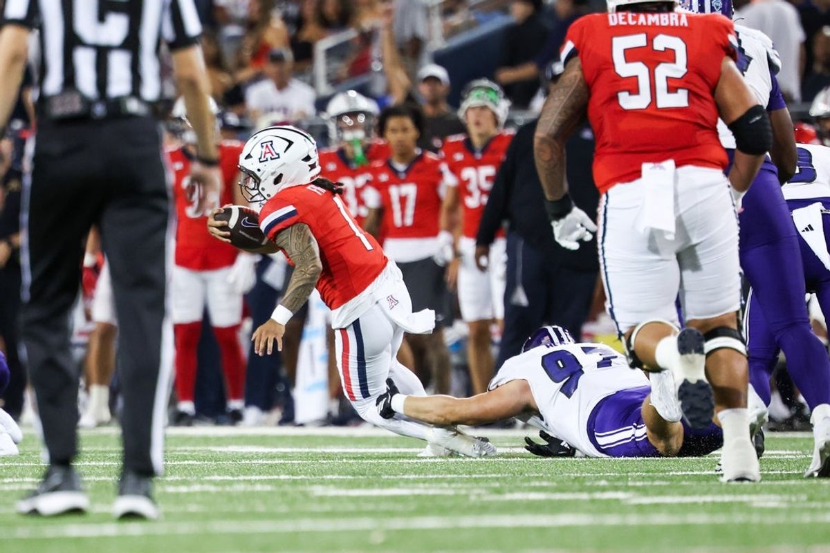 Sep 6, 2025; Tucson, Arizona, USA; Arizona Wildcats quarterback Noah Fifita (1) runs with the ball while Weber State Wildcats defensive tackle Matt Herron (97) attempts to tackle him during the first quarter of the game at Arizona Stadium. Mandatory Credit: Aryanna Frank-Imagn Images