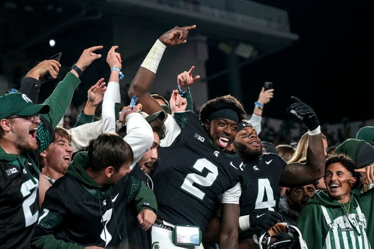 Michigan State's Aidan Chiles, center, and Marcellius Pulliam, right, celebrate with fans in the student section after MSU's win over Boston College on Saturday, Sept. 6, 2025, at Spartan Stadium in East Lansing.