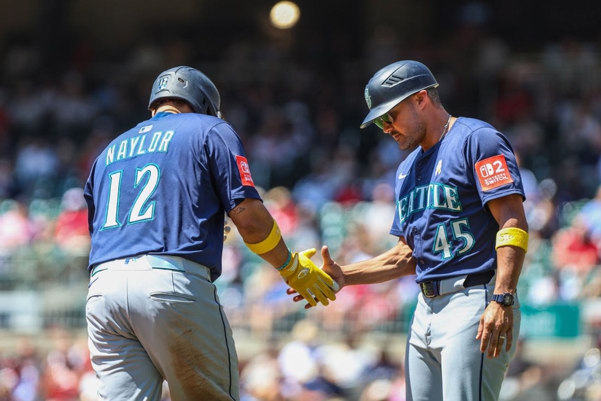 Sep 7, 2025; Cumberland, Georgia, USA; Seattle Mariners first base Josh Naylor (12) high fives third base coach Kristopher Negron (45) after hitting a home run against the Atlanta Braves during the second inning at Truist Park. Mandatory Credit: Jordan Godfree-Imagn Images