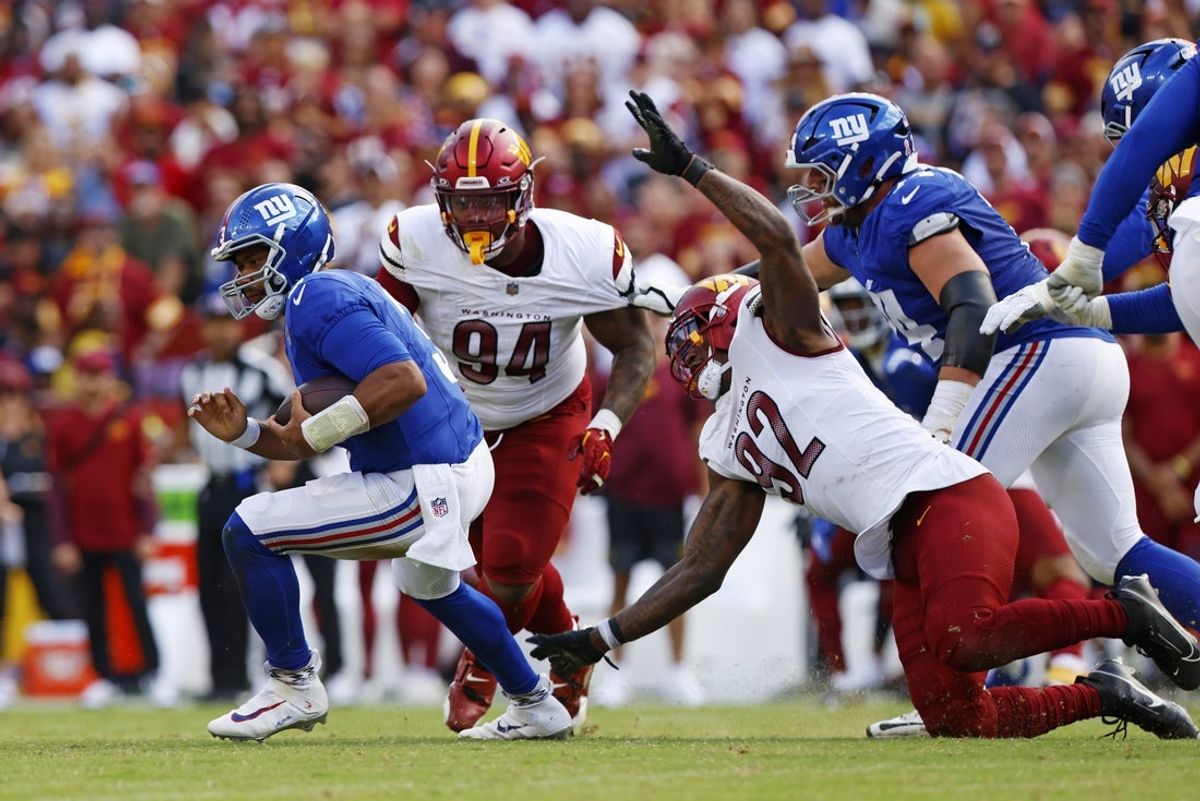 Sep 7, 2025; Landover, Maryland, USA; New York Giants quarterback Russell Wilson (3) runs away from Washington Commanders defensive end Dorance Armstrong (92) during the fourth quarter at Northwest Stadium. Mandatory Credit: Peter Casey-Imagn Images