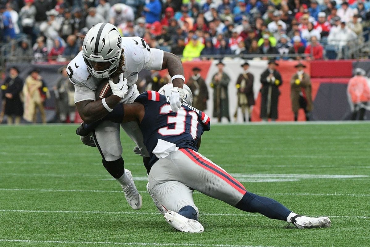 Sep 7, 2025; Foxborough, Massachusetts, USA; New England Patriots safety Craig Woodson (31) makes a tackle on Las Vegas Raiders running back Ashton Jeanty (2) during the second half at Gillette Stadium. Mandatory Credit: Bob DeChiara-Imagn Images