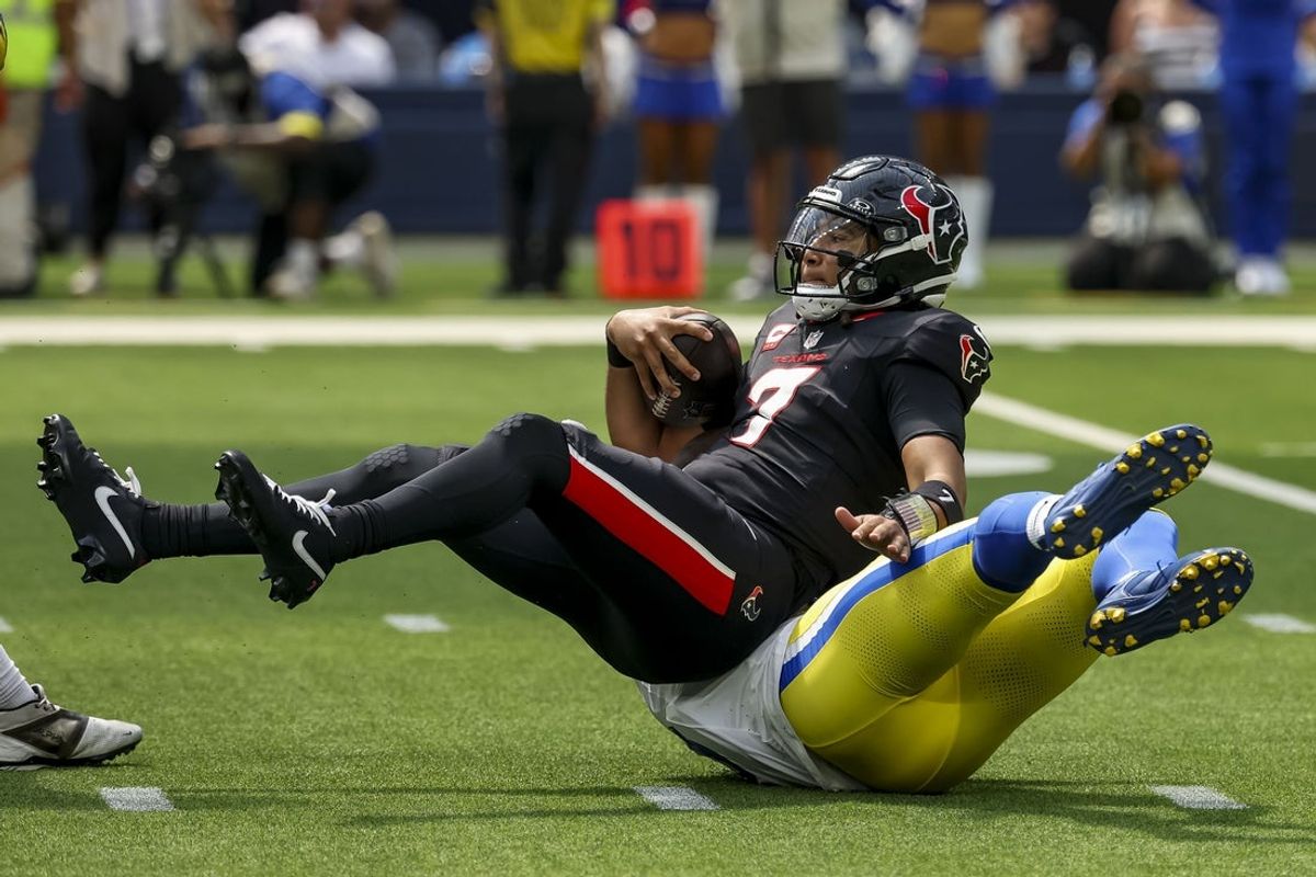 Sep 7, 2025; Inglewood, California, USA; Los Angeles Rams linebacker Byron Young (0) sacks Houston Texans quarterback C.J. Stroud (7) during the second quarter at SoFi Stadium. Mandatory Credit: Kiyoshi Mio-Imagn Images