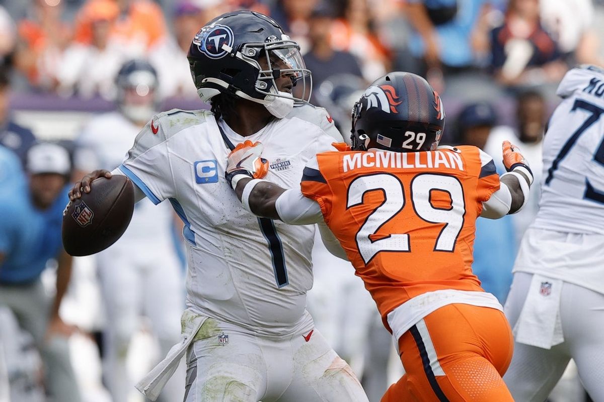 Sep 7, 2025; Denver, Colorado, USA; Denver Broncos cornerback Ja'Quan McMillian (29) hits Tennessee Titans quarterback Cam Ward (1) causing a fumble in the second half at Empower Field at Mile High. Mandatory Credit: Isaiah J. Downing-Imagn Images