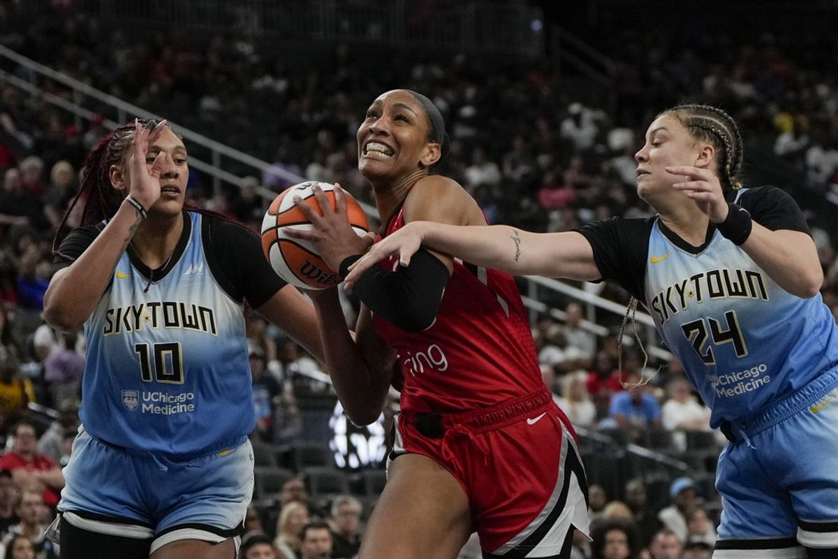 Sep 7, 2025; Las Vegas, Nevada, USA; Las Vegas Aces center A'ja Wilson (22) drives the ball between Chicago Sky center Kamilla Cardoso (10) and guard Rachel Banham (24) during the second half of a WNBA basketball game at T-Mobile Arena. Mandatory Credit: Lucas Peltier-Imagn Images