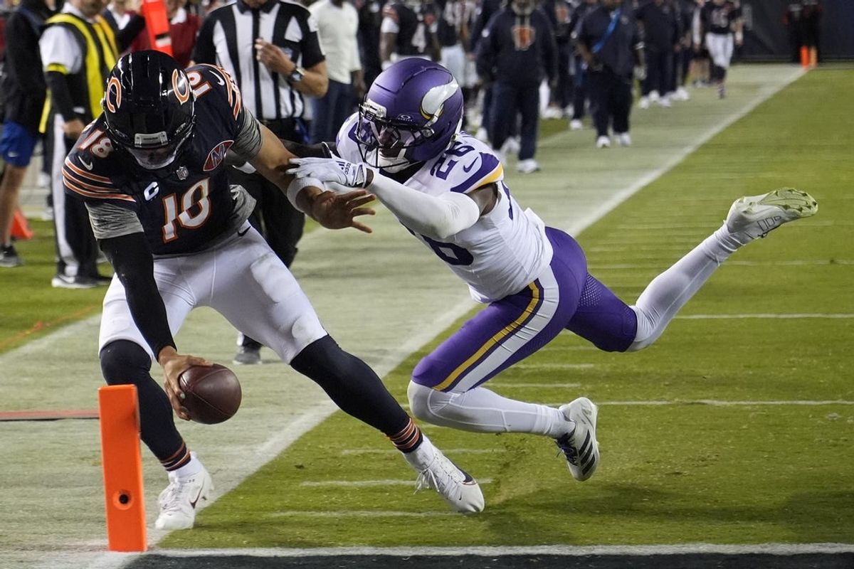 Sep 8, 2025; Chicago, Illinois, USA; Chicago Bears quarterback Caleb Williams (18) rushes the ball past Minnesota Vikings safety Theo Jackson (26) during the second half at Soldier Field. Mandatory Credit: David Banks-Imagn Images