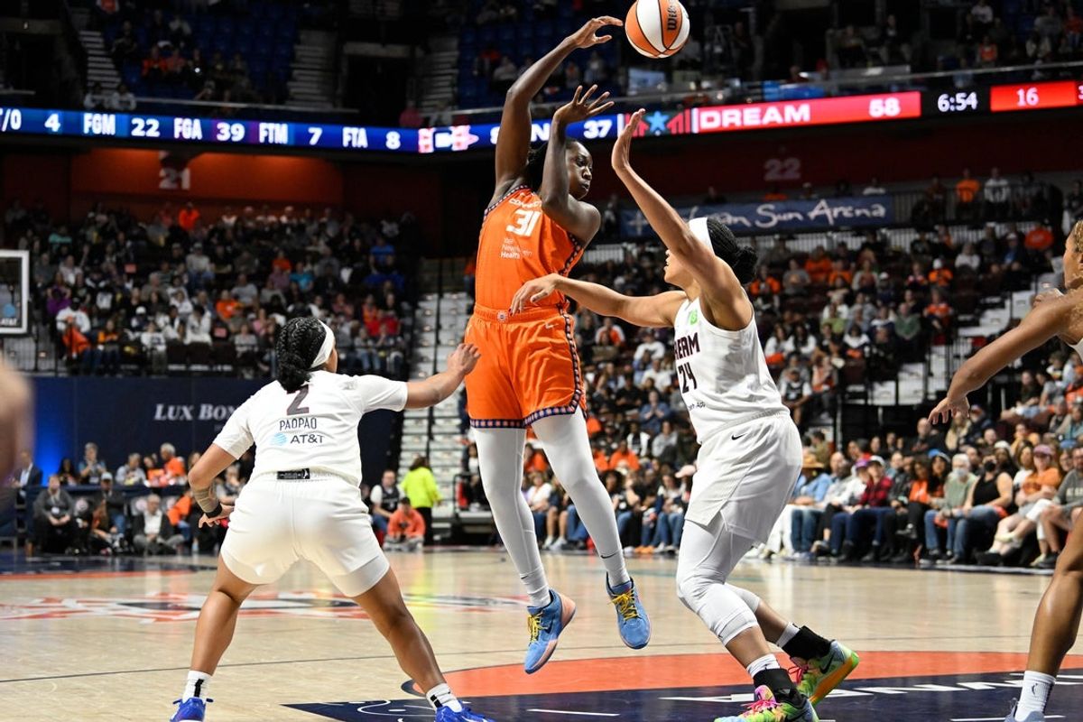 Sep 10, 2025; Uncasville, Connecticut, USA; Connecticut Sun center Tina Charles (31) passes the ball against Atlanta Dream forward Brionna Jones (24) and guard Te-Hina Paopao (2) during the second half at Mohegan Sun Arena. Mandatory Credit: Eric Canha-Imagn Images