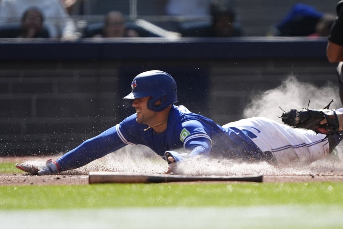 Sep 11, 2025; Toronto, Ontario, CAN; Toronto Blue Jays designated hitter George Springer (4) beats the tag from Houston Astros catcher Yainer Diaz (21) to score during the first inning at Rogers Centre. Mandatory Credit: John E. Sokolowski-Imagn Images