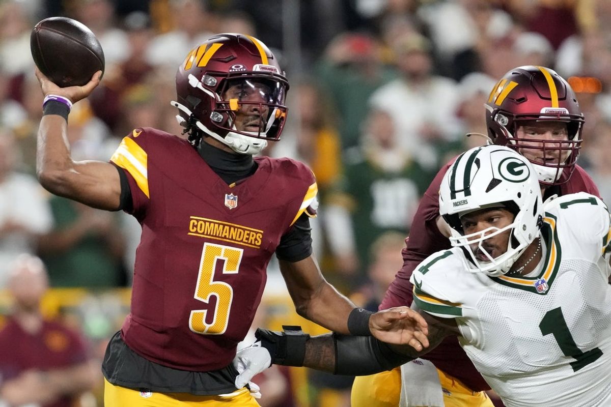Sep 11, 2025; Green Bay, Wisconsin, USA; Washington Commanders quarterback Jayden Daniels (5) passes against Green Bay Packers defensive end Micah Parsons (1) in the first quarter at Lambeau Field. Mandatory Credit: Jeff Hanisch-Imagn Images