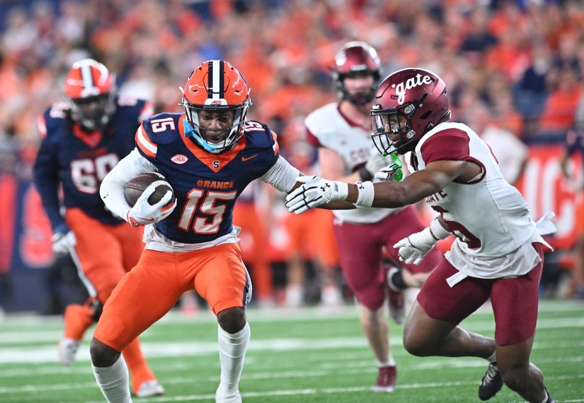 Sep 12, 2025; Syracuse, New York, USA; Syracuse Orange wide receiver Darrell Gill Jr. (15) tries to avoid a tackle by Colgate Raiders defensive back Tymir Wynn (6) in the first quarter at the JMA Wireless Dome. Mandatory Credit: Mark Konezny-Imagn Images