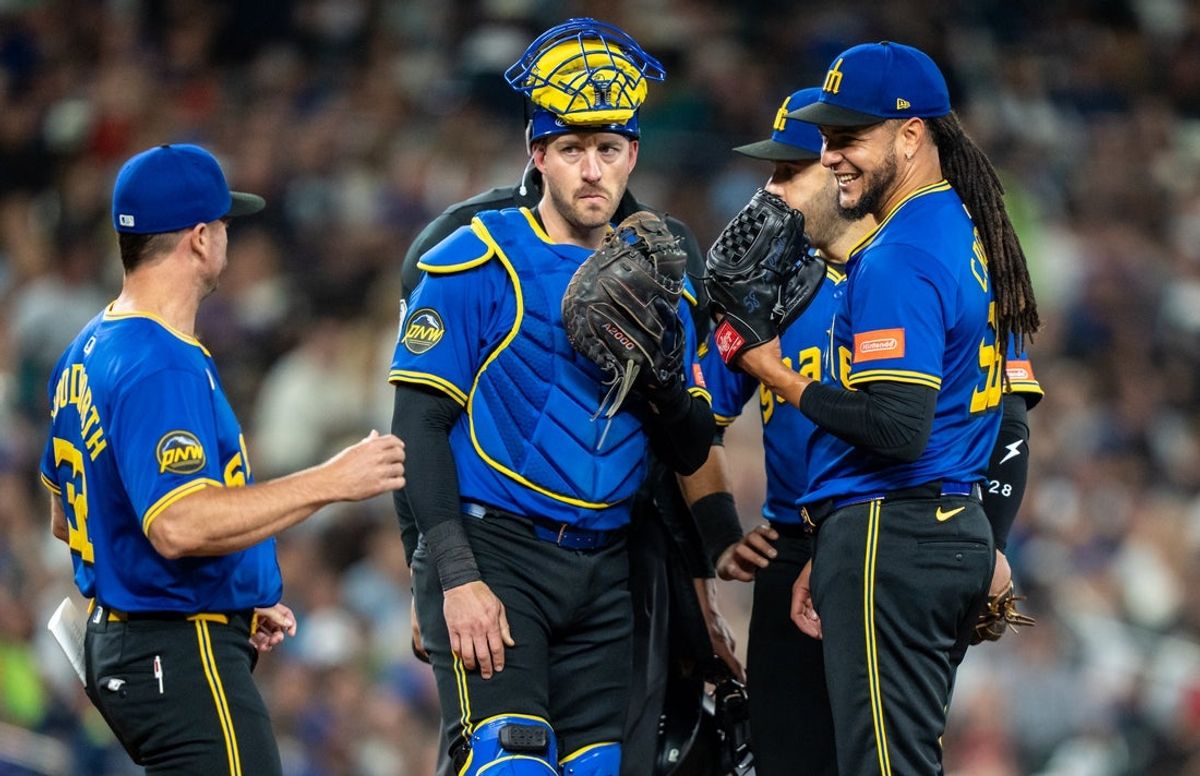 Sep 12, 2025; Seattle, Washington, USA; Seattle Mariners starting pitcher Luis Castillo (58), right, meets at the mound with pitching coach Pete Woodworth, left, catcher Mitch Garver (18), second from left, and third baseman Eugenio Suarez (28) during the sixth inning against the Los Angeles Angels at T-Mobile Park. Mandatory Credit: Stephen Brashear-Imagn Images