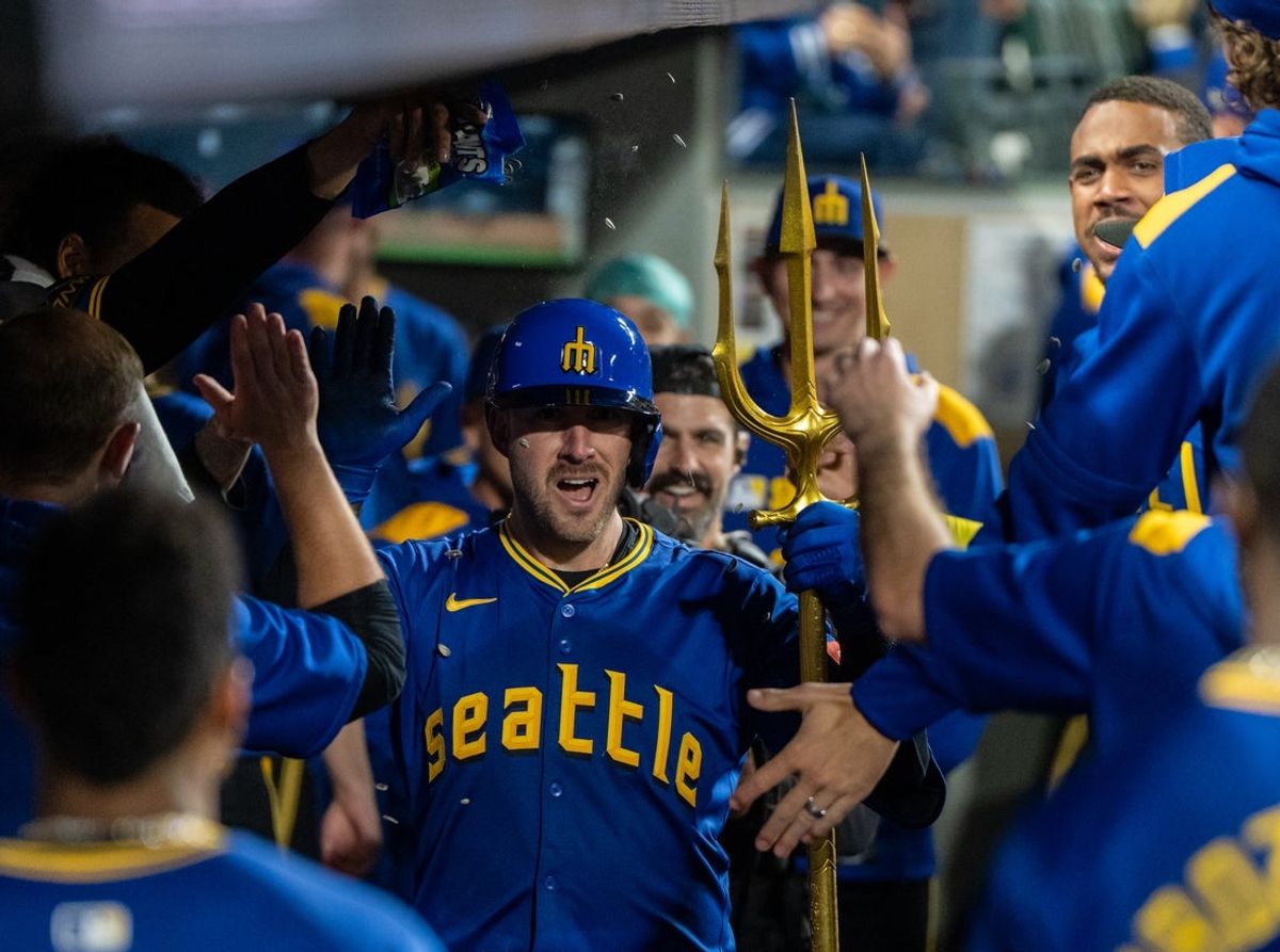 Sep 12, 2025; Seattle, Washington, USA; Seattle Mariners catcher Mitch Garver (18) celebrates in the dugout after hitting a solo home run during the seventh inning against the Los Angeles Angels at T-Mobile Park. Mandatory Credit: Stephen Brashear-Imagn Images