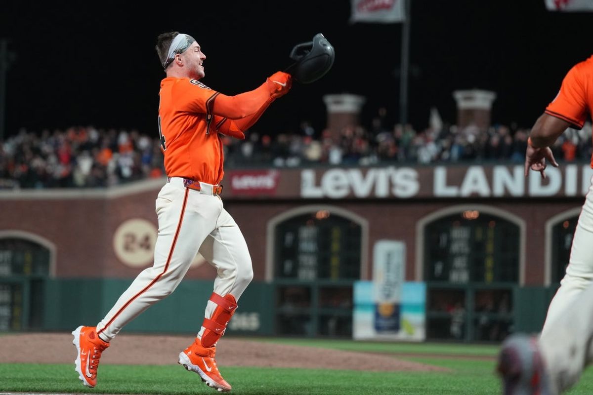 Sep 12, 2025; San Francisco, California, USA; San Francisco Giants catcher Patrick Bailey (14) tosses his helmet while rousing the bases after hitting a walk off grand slam home run against the Los Angeles Dodgers during the tenth inning at Oracle Park. Mandatory Credit: Darren Yamashita-Imagn Images