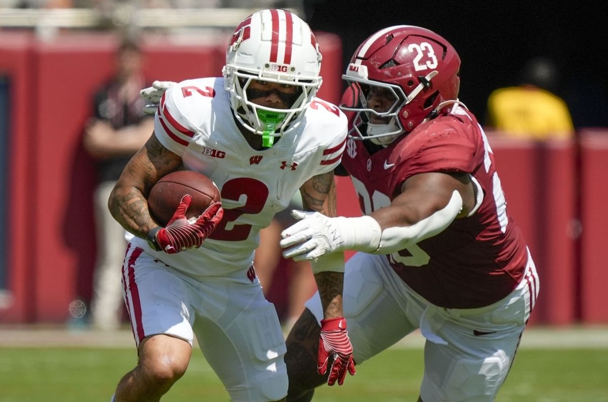 Sep 13, 2025; Tuscaloosa, Alabama, USA;  Wisconsin wide receiver Trech Kekahuna (2) runs the ball and is pursued by Alabama defensive lineman James Smith (23) at Saban Field at Bryant-Denny Stadium.  Mandatory Credit: Gary Cosby-USA TODAY Network via Imagn Images