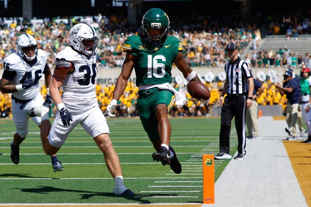 Sep 13, 2025; Waco, Texas, USA; Baylor Bears wide receiver Kobe Prentice (16) scores a touchdown against Samford Bulldogs linebacker Carson Sloan (30) during the first half at McLane Stadium. Mandatory Credit: Chris Jones-Imagn Images