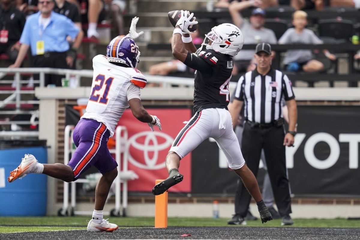 Sep 13, 2025; Cincinnati, Ohio, USA;  Cincinnati Bearcats wide receiver Cyrus Allen (4) makes a catch for a touchdown against Northwestern State Demons cornerback Ja'Marion Bonner (21) in the first half at Nippert Stadium. Mandatory Credit: Aaron Doster-Imagn Images