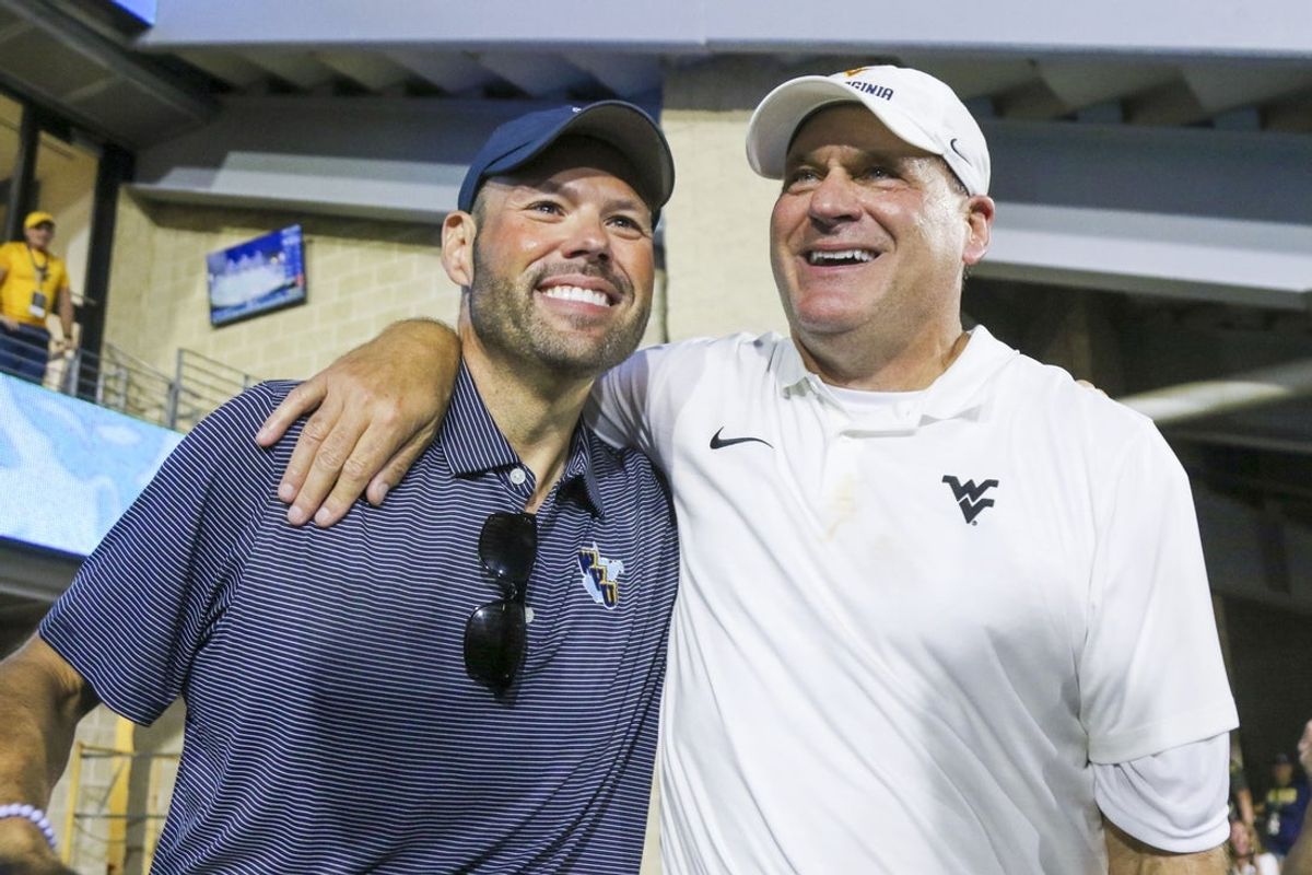 Sep 13, 2025; Morgantown, West Virginia, USA; West Virginia Mountaineers head coach Rich Rodriguez celebrates with West Virginia University athletic director Wren Baker after defeating the Pittsburgh Panthers at Milan Puskar Stadium. Mandatory Credit: Ben Queen-Imagn Images