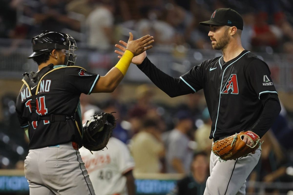 Sep 13, 2025; Minneapolis, Minnesota, USA; Arizona Diamondbacks catcher Gabriel Moreno (14) and relief pitcher John Curtiss (46) celebrate the win over the Minnesota Twins after ten innings at Target Field. Mandatory Credit: Bruce Kluckhohn-Imagn Images