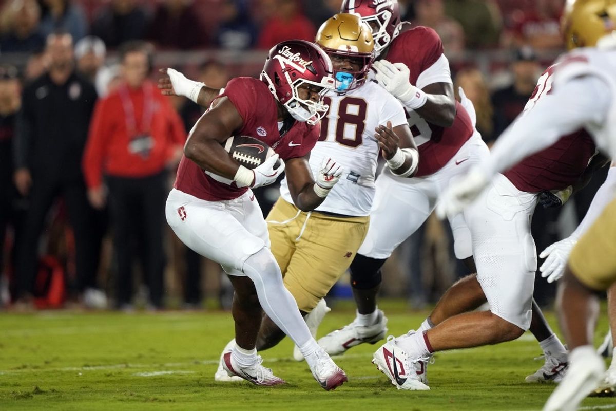 Sep 13, 2025; Stanford, California, USA; Stanford Cardinal running back Micah Ford (center left) carries the ball against the Boston College Eagles during the first quarter at Stanford Stadium. Mandatory Credit: Darren Yamashita-Imagn Images
