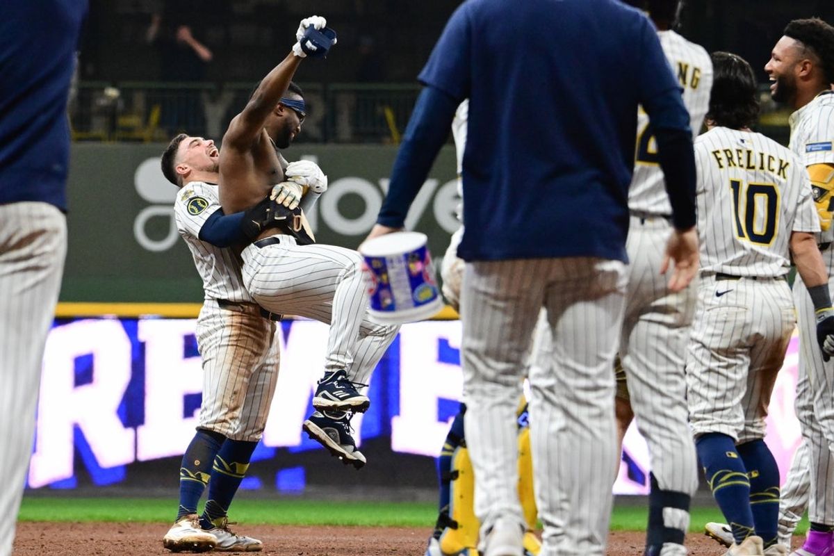 Sep 13, 2025; Milwaukee, Wisconsin, USA; Milwaukee Brewers second baseman Andruw Monasterio (14) is hugged by third baseman Caleb Durbin (21) after driving in the winning run in the tenth inning against the St. Louis Cardinals at American Family Field. Mandatory Credit: Benny Sieu-Imagn Images