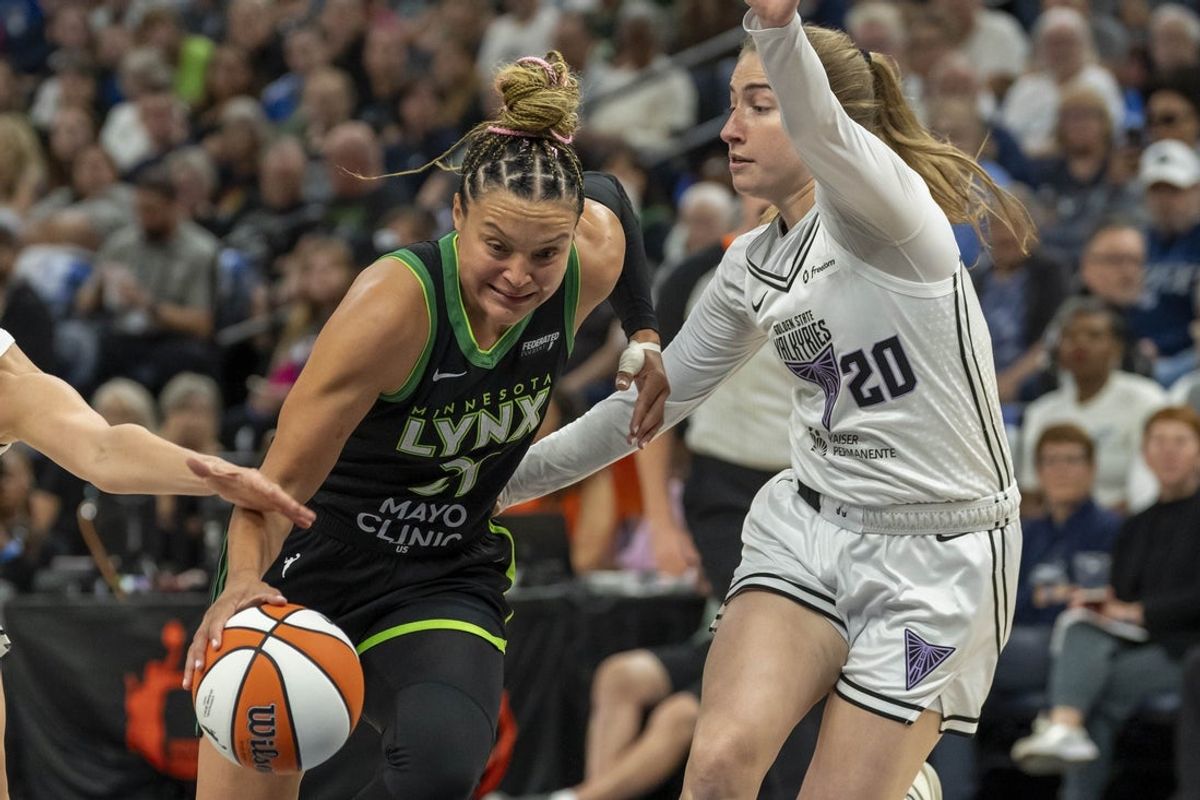 Sep 14, 2025; Minneapolis, Minnesota, USA; Minnesota Lynx guard Kayla McBride (21) dribbles the ball past Golden State Valkyries guard Kate Martin (20) in the first half during game one of round one for the 2025 WNBA Playoffs at Target Center. Mandatory Credit: Jesse Johnson-Imagn Images