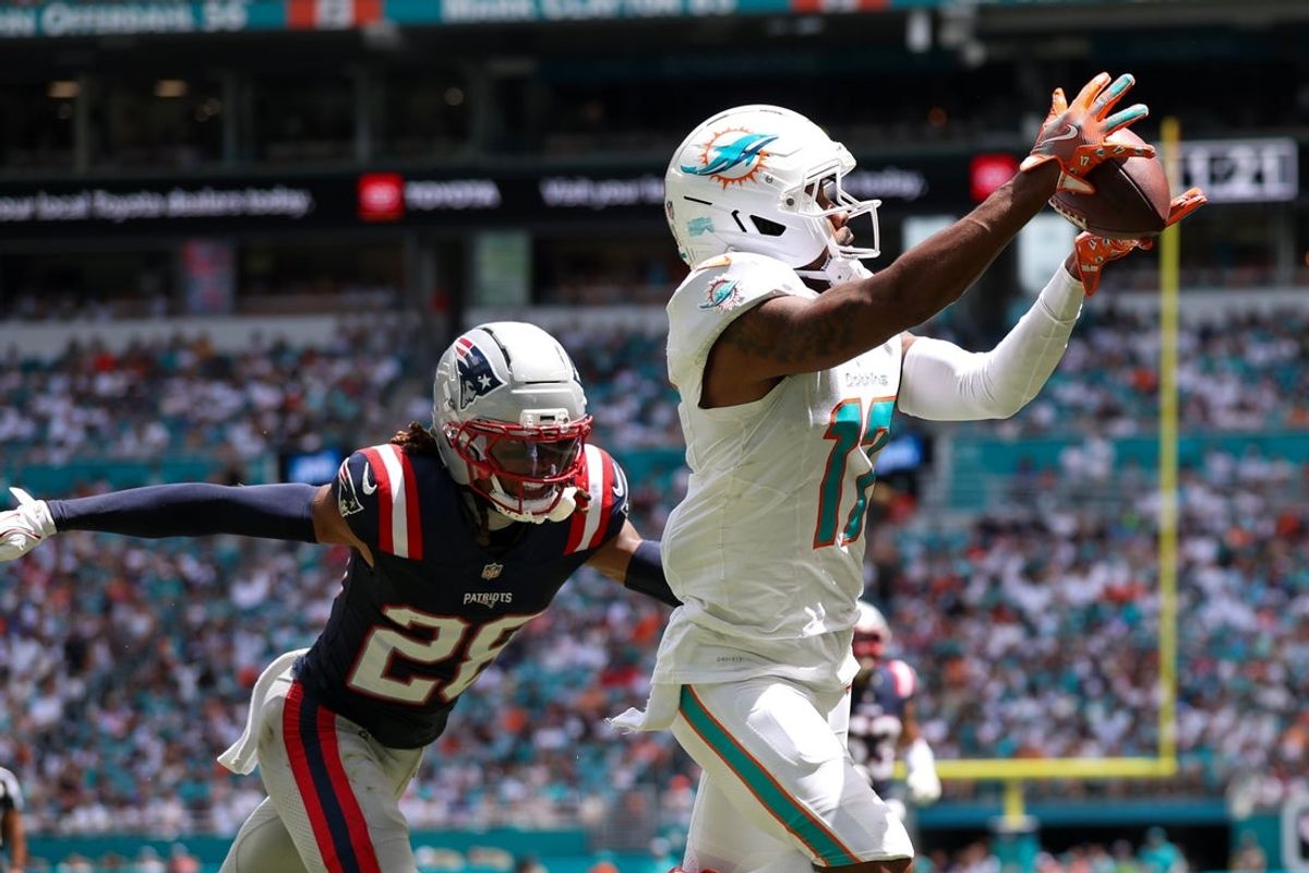 Sep 14, 2025; Miami Gardens, Florida, USA; Miami Dolphins wide receiver Jaylen Waddle (17) catches a pass for a touchdown defended by New England Patriots cornerback Alex Austin (28) in the second quarter  at Hard Rock Stadium. Mandatory Credit: Nathan Ray Seebeck-Imagn Images