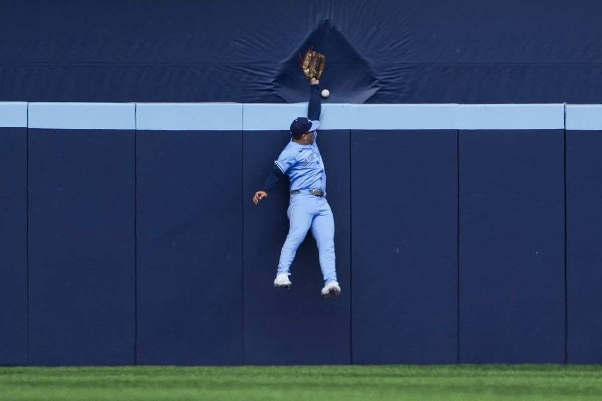 Sep 14, 2025; Toronto, Ontario, CAN; Toronto Blue Jays outfielder Daulton Varsho (5) attempts to catch a home run by Baltimore Orioles first base Coby Mayo (16) (not in photo) during the second inning at Rogers Centre. Mandatory Credit: Kevin Sousa-Imagn Images