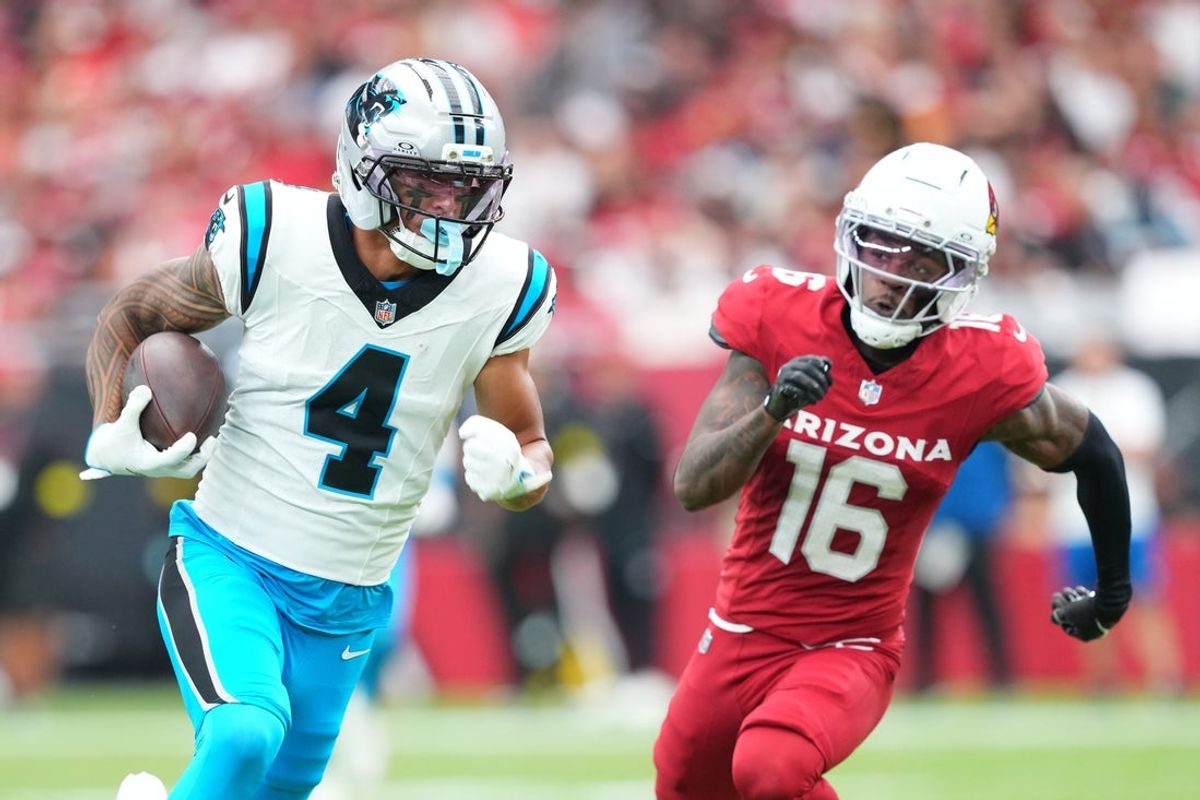 Sep 14, 2025; Glendale, Arizona, USA;  Carolina Panthers wide receiver Tetairoa McMillan (4) runs with the ball during the first quarter against Arizona Cardinals cornerback Max Melton (16) at State Farm Stadium. Mandatory Credit: Joe Camporeale-Imagn Images