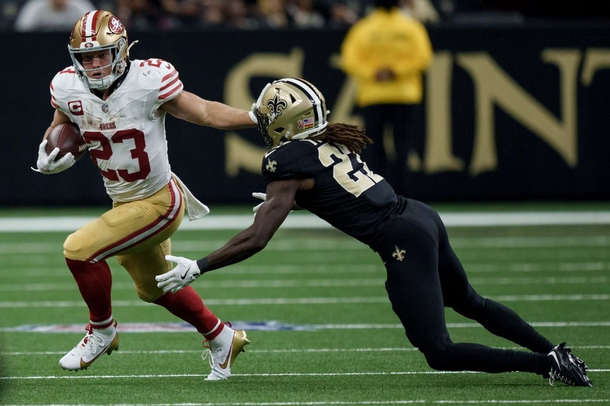 Sep 14, 2025; New Orleans, Louisiana, USA;  San Francisco 49ers running back Christian McCaffrey (23) runs against New Orleans Saints cornerback Isaac Yiadom (27) during the first half at Caesars Superdome. Mandatory Credit: Matthew Hinton-Imagn Images