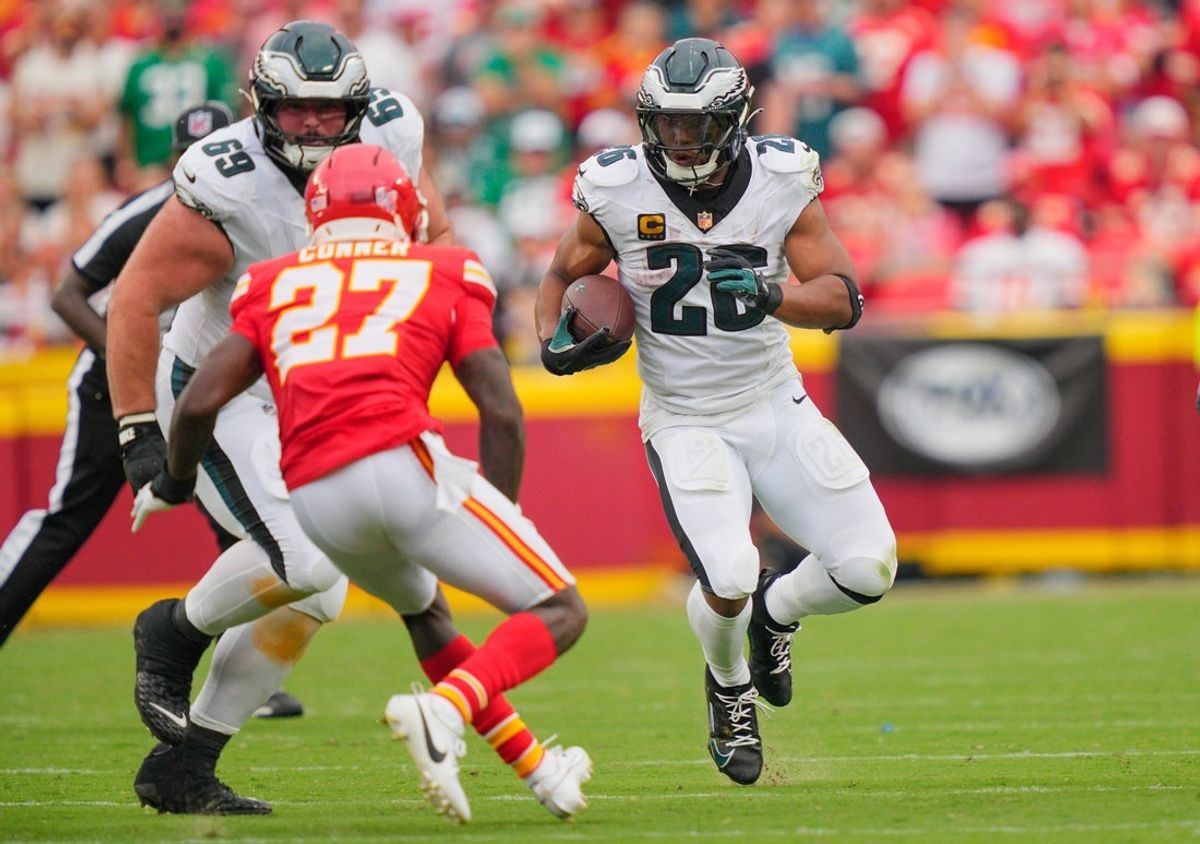 Sep 14, 2025; Kansas City, Missouri, USA; Philadelphia Eagles running back Saquon Barkley (26) carries the ball defended by Kansas City Chiefs safety Chamarri Conner (27) during the fourth quarter of the game at GEHA Field at Arrowhead Stadium. Mandatory Credit: Jay Biggerstaff-Imagn Images