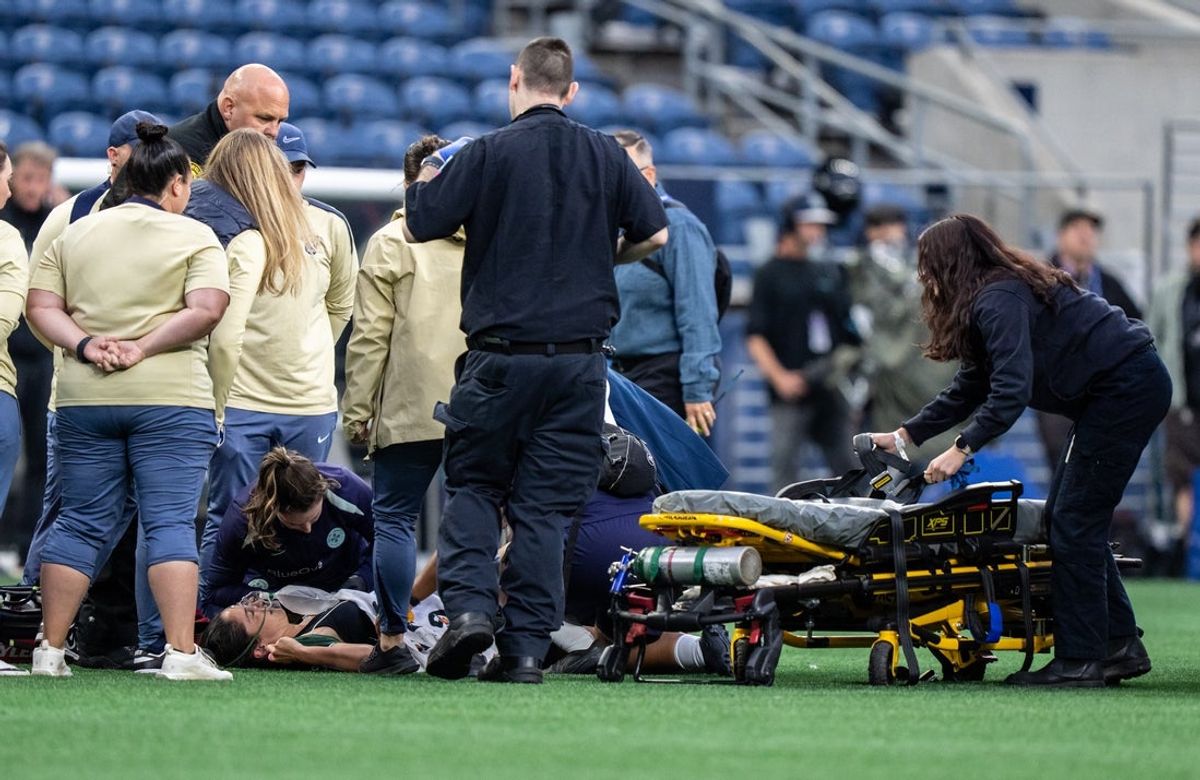 Sep 14, 2025; Seattle, Washington, USA; Racing Lousville midfielder Savannah DeMelo (7) is tended to by medical personnel before being taken from the field in an ambulance during the first half against the Seattle Reign at Lumen Field. Mandatory Credit: Stephen Brashear-Imagn Images