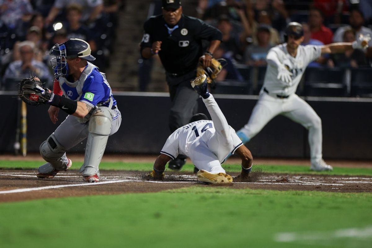 Sep 15, 2025; Tampa, Florida, USA; Tampa Bay Rays left fielder Chandler Simpson (14) slides safely into home plate against the Toronto Blue Jays in the first inning at George M. Steinbrenner Field. Mandatory Credit: Nathan Ray Seebeck-Imagn Images
