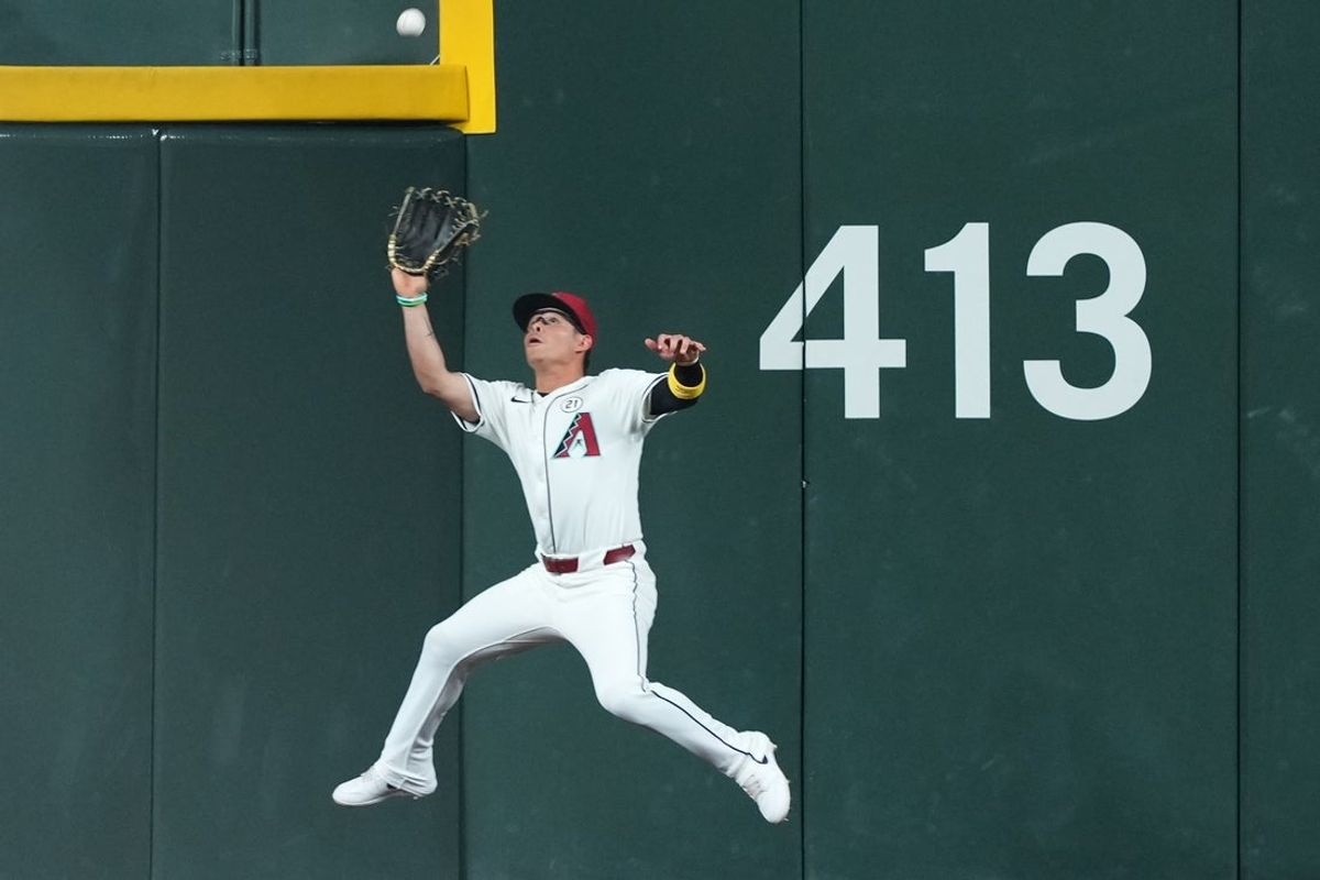 Sep 15, 2025; Phoenix, Arizona, USA; Arizona Diamondbacks outfielder Alek Thomas (5) makes a leaping catch during the fourth seventh inning against the San Francisco Giants at Chase Field. Mandatory Credit: Joe Camporeale-Imagn Images