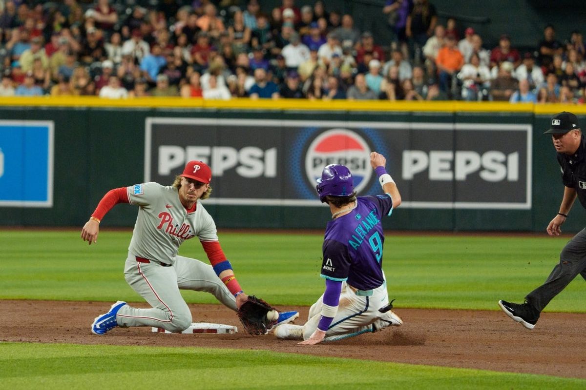 Sep 19, 2025; Phoenix, Arizona, USA;  Philadelphia Phillies infielder Bryson Stott (5) tags Arizona Diamondbacks infielder Blaze Alexander (9) to make the out in the second inning at Chase Field. Mandatory Credit: Allan Henry-Imagn Images