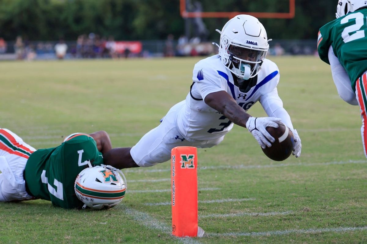 Eric McFarland (3) da IMG Academy marca um touchdown contra Tamajh Mitchell (7) do Mandarin durante o primeiro quarto de uma partida de futebol do ensino médio na Mandarin High School, sexta-feira, 19 de setembro de 2025, em Jacksonville, Flórida.